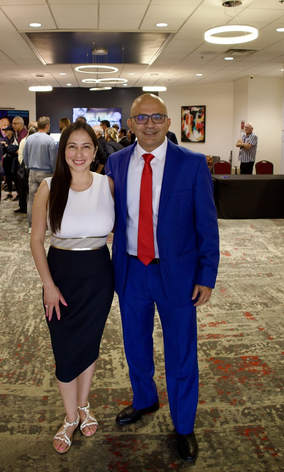 Dr. Maruti Sharma in a blue suit standing with Sandra Y. at an event, 2026